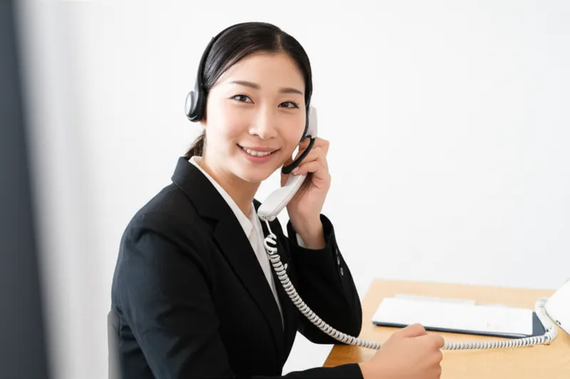 ヘッドセットで電話対応するスタッフ